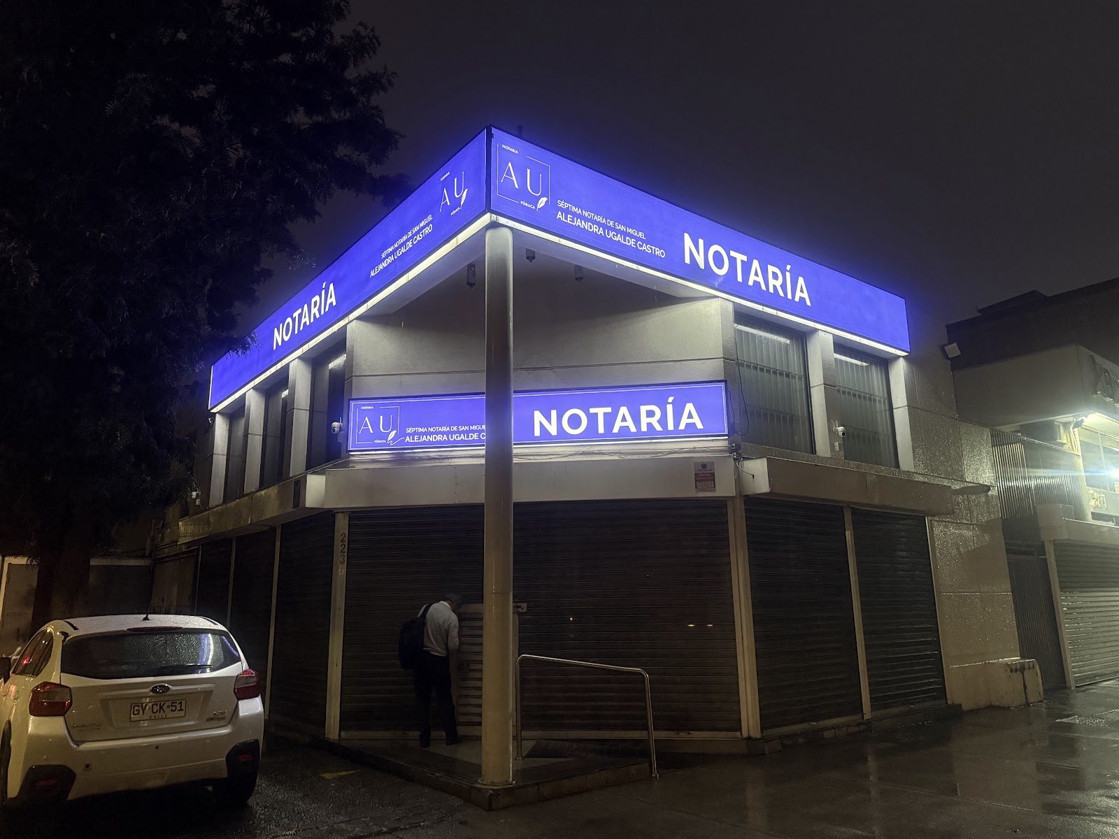 Notaría Ugalde iluminada al anochecer en San Joaquín